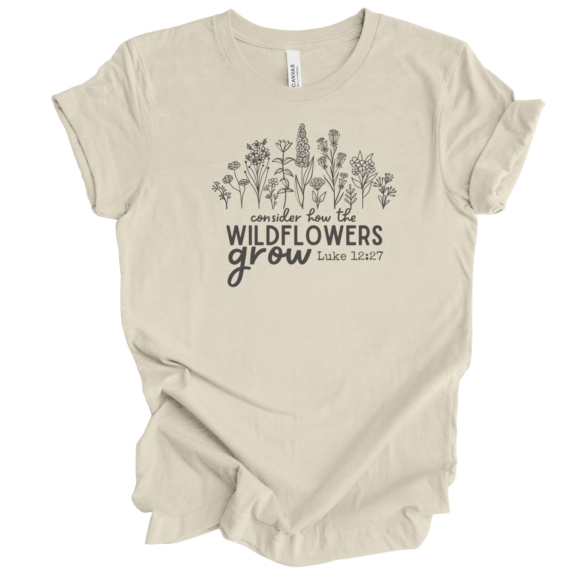 Christian T-shirt with wildflower illustration and text that says "Consider how the wildflowers grow", referencing the Luke 12:27 Bible verse. The design is direct to garment (DTG) printed on a soft-cream colored Bella + Canvas  brand t-shirt and available in sizes S-3XL.